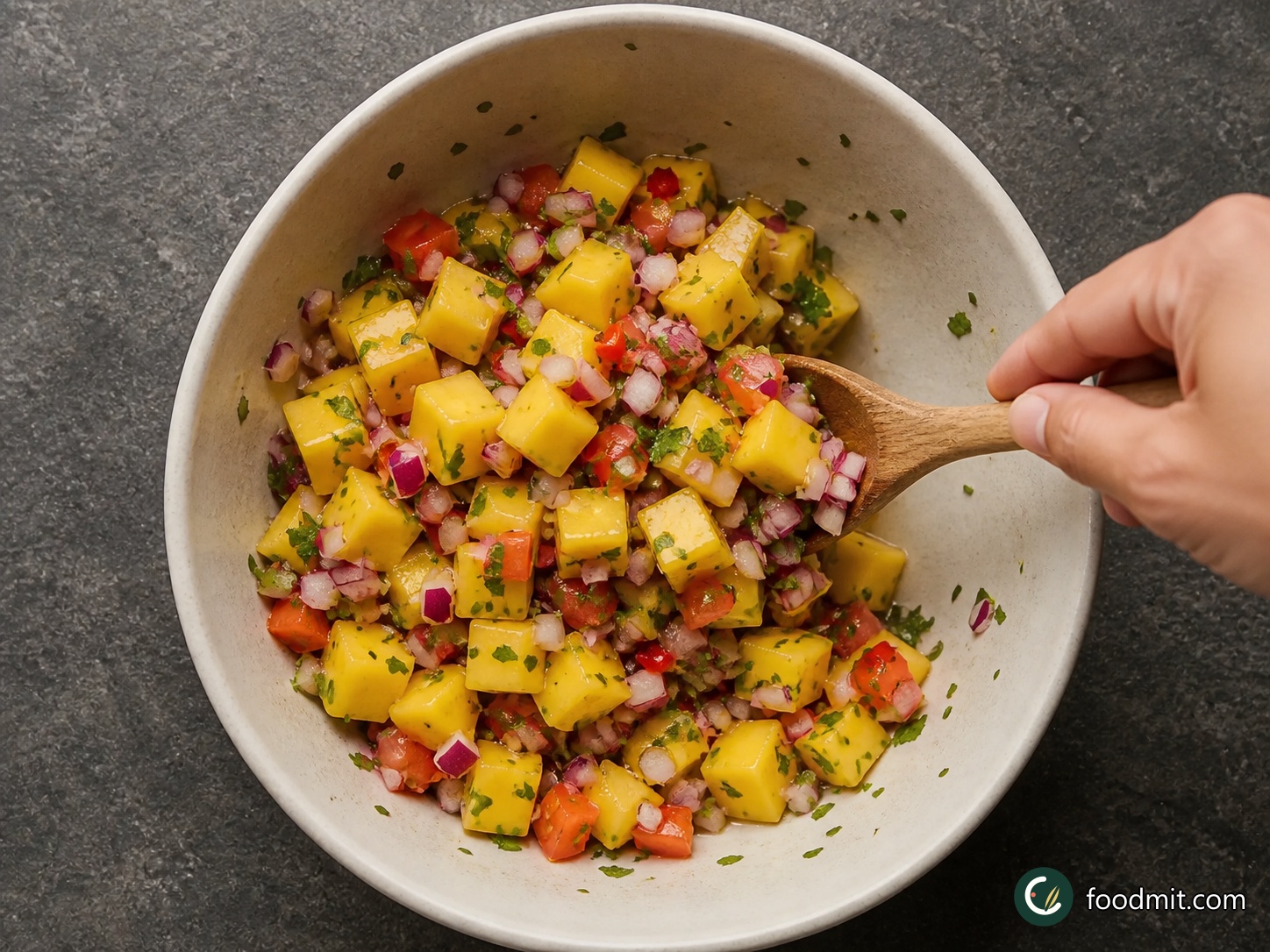 While the wings cook, gently combine the mango cubes, red onion, tomato, coriander and red chilli in a bowl. Add the lemon juice and fold once more without crushing the fruit. Spoon the salsa around the grilled wings when they reach the platter.