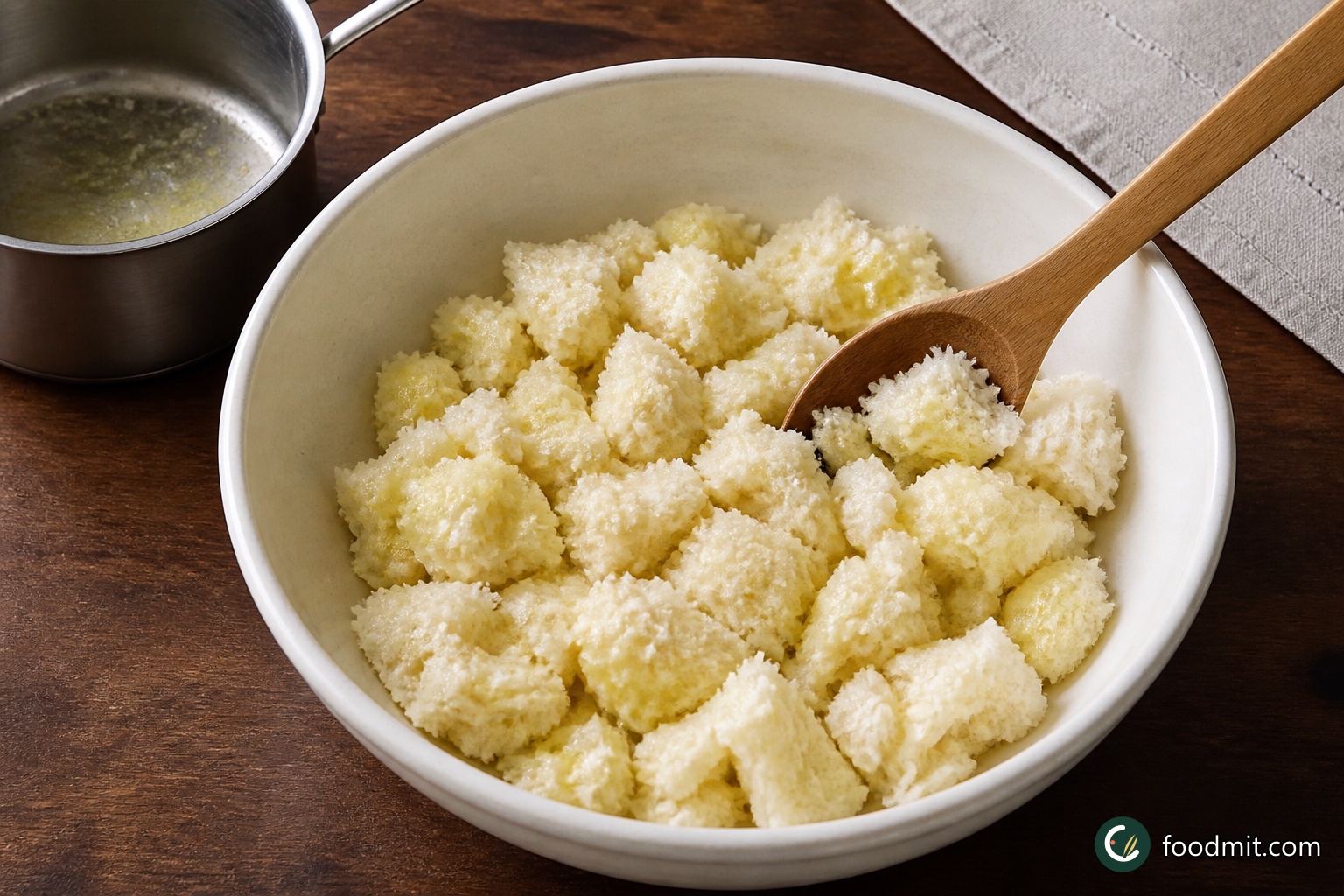 Put the torn bread in a medium bowl, pour over the 2 tablespoons of melted butter, and toss until the irregular pieces are lightly coated. Leave this topping aside while you make the sauce.