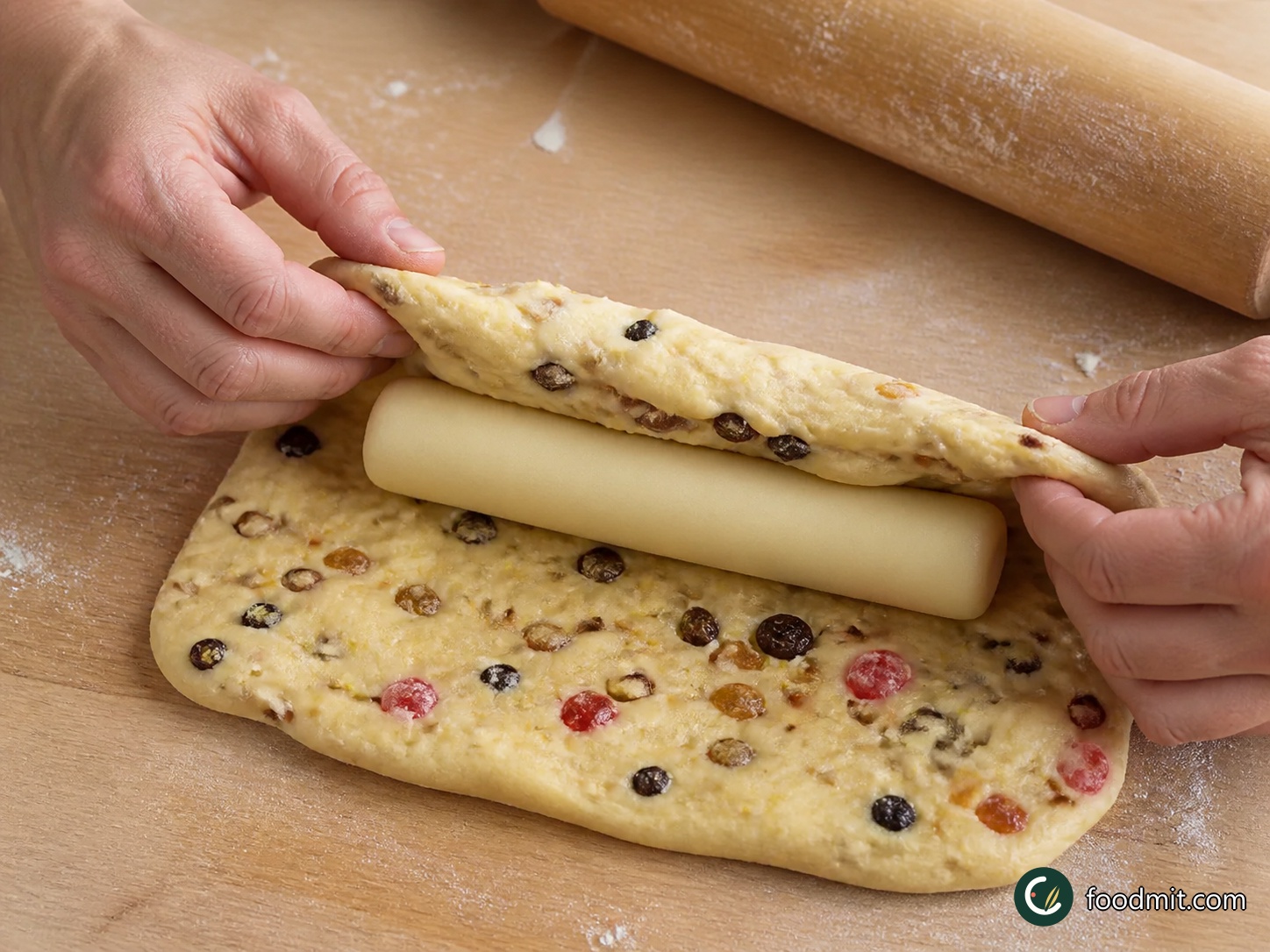 Dust the board with the remaining 25 g flour, turn out the risen dough, press out the gas, and knead it back into a smooth ball. With a floured rolling pin, roll it to a 15 x 20 cm oblong. Shape the marzipan into a 14 cm log and lay it across the middle, stopping short of both edges. Fold one long side over it, then the other; turn the loaf seam-side down and set it diagonally on a lined or well-greased large baking sheet, leaving ample room around it.