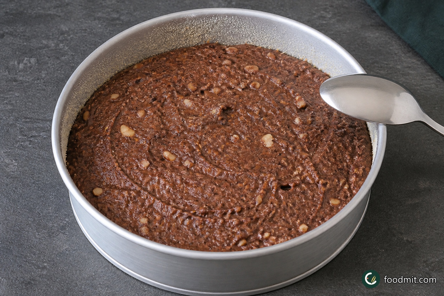 Using a large metal spoon, fold the egg whites into the chocolate mixture a few tablespoons at a time. Cut down through the center, sweep across the bottom, and lift the mixture over the top with a high, gentle motion. Continue only until no white streaks remain, then spoon the batter evenly into the prepared tin.