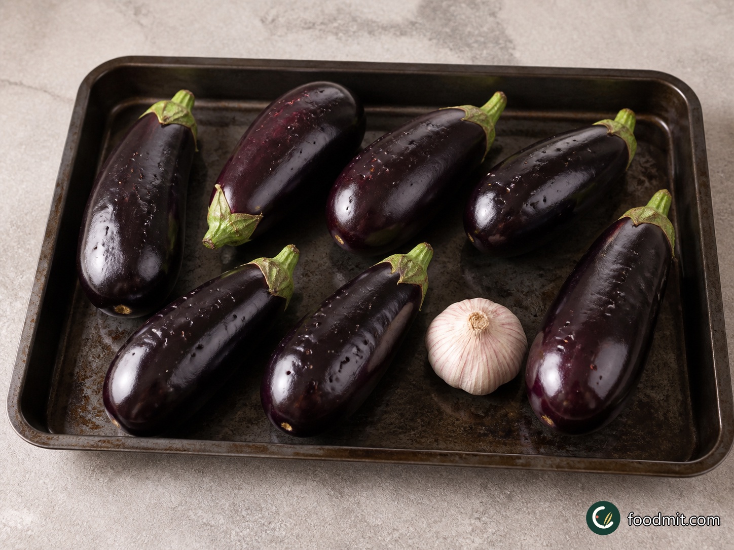 Pierce each whole aubergine in several places so steam can escape during roasting. Put them in a second roasting tray with the entire unpeeled bulb of garlic. Keep the aubergines and garlic whole at this stage; they will roast beside the chicken and be finished after their centres have become completely soft.